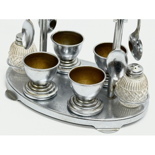 166 - A 1920’s Art Deco chrome and Bakelite breakfast set. Egg cups, salt and pepper shakers and 4 spoons ... 