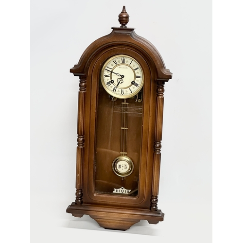 658 - A 19th century style Schmeckenbecker wall clock. With key and pendulum. 63cm