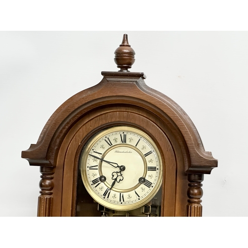 658 - A 19th century style Schmeckenbecker wall clock. With key and pendulum. 63cm