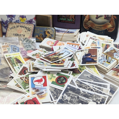 409 - A large collection of 20th Century international stamps, tins, cigarette cards, etc.