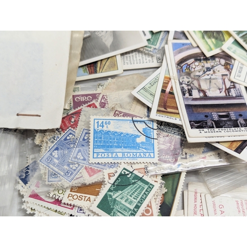 409 - A large collection of 20th Century international stamps, tins, cigarette cards, etc.