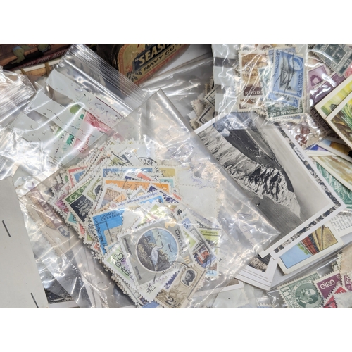 409 - A large collection of 20th Century international stamps, tins, cigarette cards, etc.