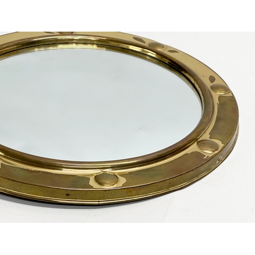 422 - A Mid 20th Century brass framed ships porthole style convex mirror. 30cm