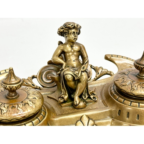 37 - A Late 19th Century brass inkstand/inkwell with sitting putti and pierced brass base. 32x20x11cm