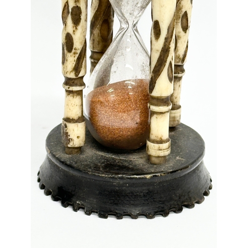 204 - A Late 19th Century bone and ebony hourglass. 9.5cm