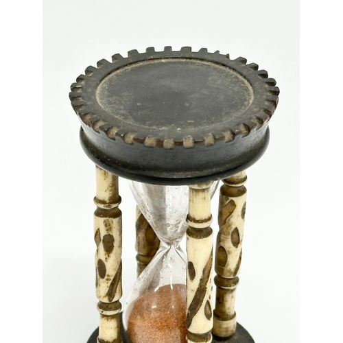 204 - A Late 19th Century bone and ebony hourglass. 9.5cm