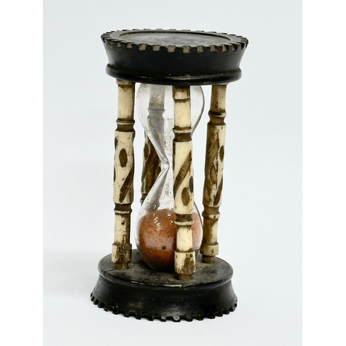 204 - A Late 19th Century bone and ebony hourglass. 9.5cm