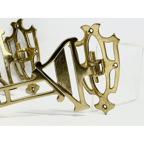 219 - A pair of Early 20th Century brass harp design wall mounted candleholders. 22cm