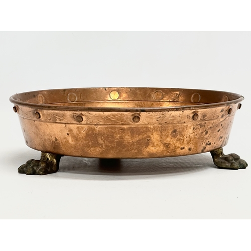 95 - An Early 20th Century shallow copper planter with 3 brass lion paw feet. 26x7.5cm