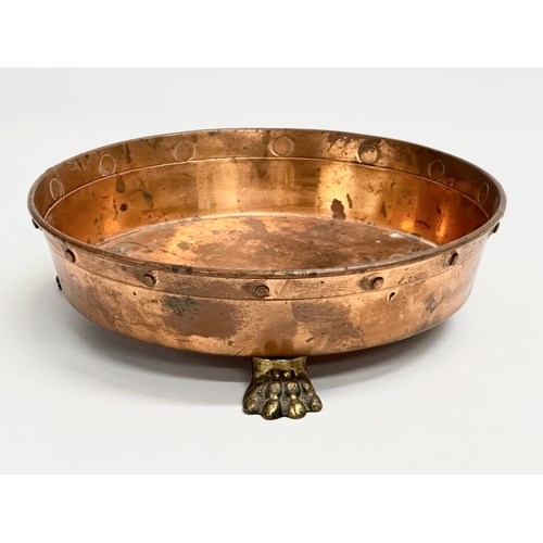 95 - An Early 20th Century shallow copper planter with 3 brass lion paw feet. 26x7.5cm