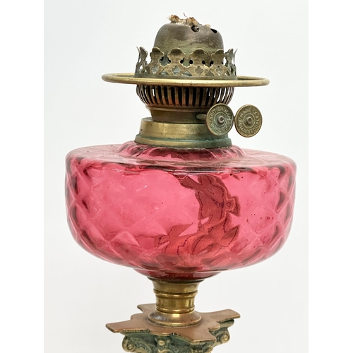 320 - A large Victorian Ruby glass oil lamp with brass Corinthian style column. 60cm