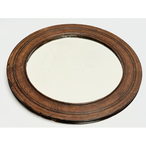 354 - An Early 20th Century oak framed spinning wheel mirror. Circa 1900. 52.5cm