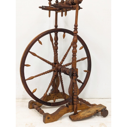 301 - An Early 20th Century spinning wheel. 62x108cm