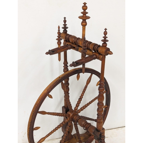 301 - An Early 20th Century spinning wheel. 62x108cm