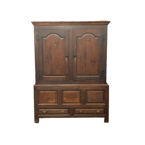 848 - An early George II oak press/house keepers cupboard with raised and fielded panels. With original wo... 