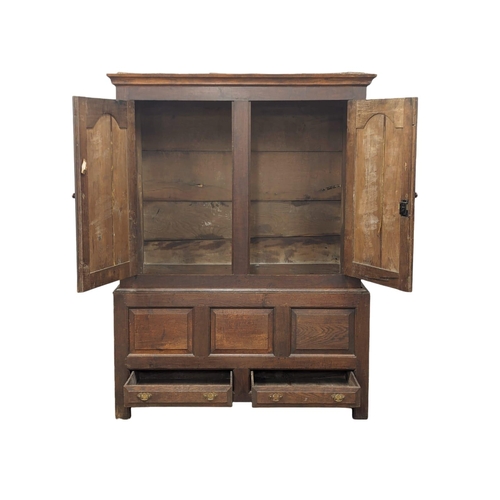 848 - An early George II oak press/house keepers cupboard with raised and fielded panels. With original wo... 