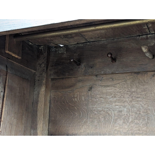 848 - An early George II oak press/house keepers cupboard with raised and fielded panels. With original wo... 