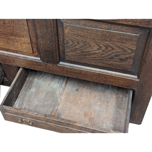 848 - An early George II oak press/house keepers cupboard with raised and fielded panels. With original wo... 