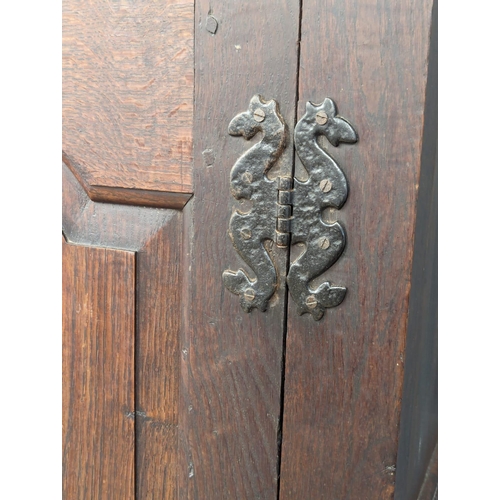 848 - An early George II oak press/house keepers cupboard with raised and fielded panels. With original wo... 