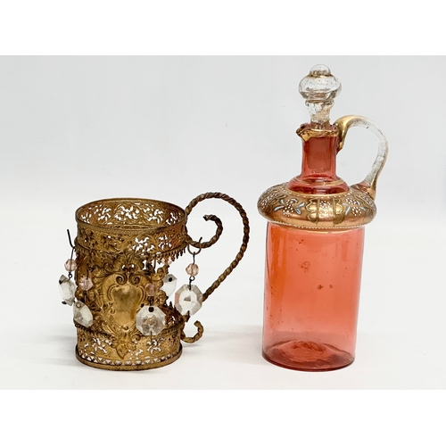 5 - An Early 19th Century French gilt cranberry glass decanter with original gilt brass holder and dropl... 