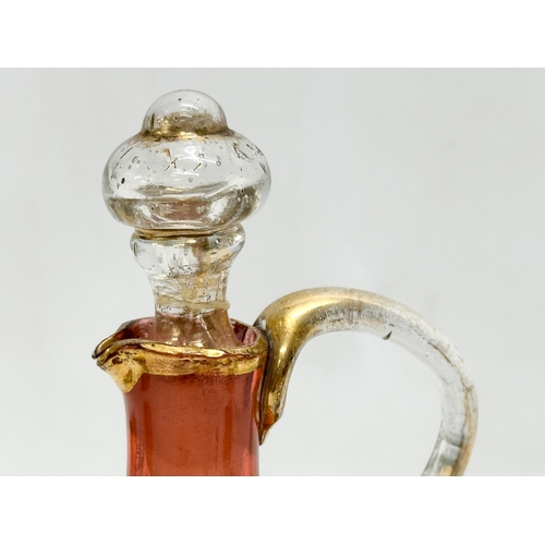 5 - An Early 19th Century French gilt cranberry glass decanter with original gilt brass holder and dropl... 