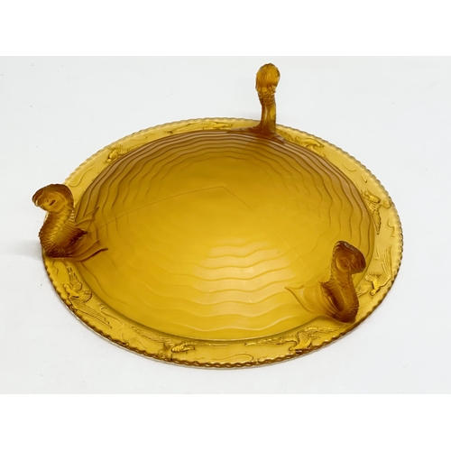 124 - A large 1930’s S. Reich & Co amber glass centrepiece bowl with sea fish design rim and raised on 3 k... 