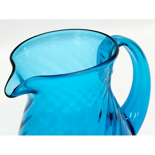 177 - A 1930’s blue swirl glass water jug. 15x11x15cm