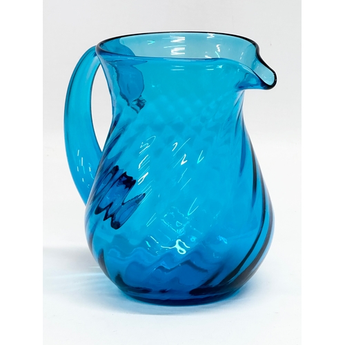 177 - A 1930’s blue swirl glass water jug. 15x11x15cm