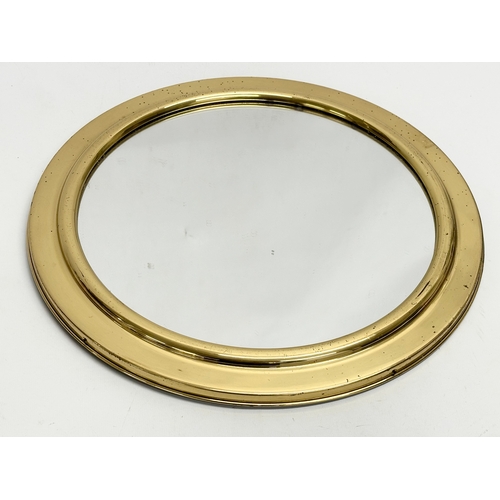 243 - A vintage brass framed porthole style mirror. 36.5cm