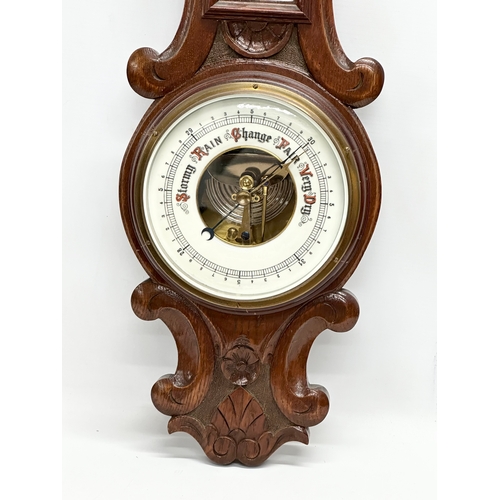 247 - An Early 20th Century oak barometer. Circa 1900. 76cm