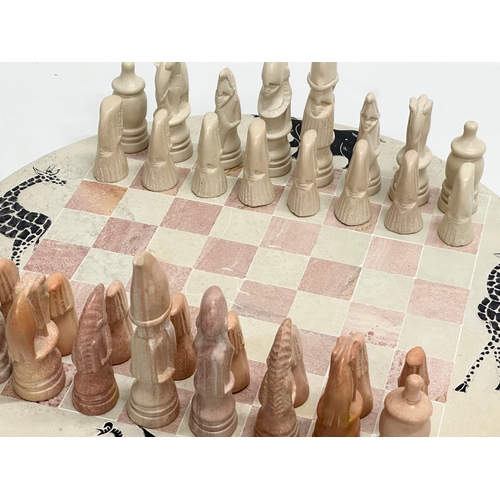 284 - An African soapstone chess set. 40.5cm