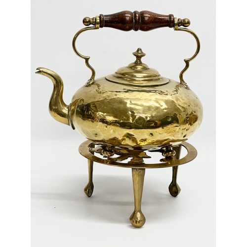 569 - A Victorian brass kettle and later stand.