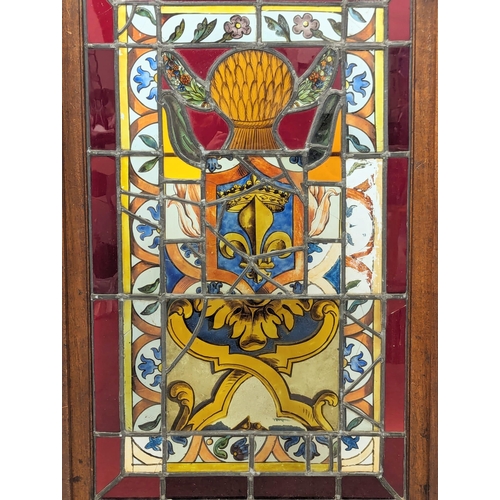 831 - An Edwardian mahogany stained glass fire screen. 53x102cm