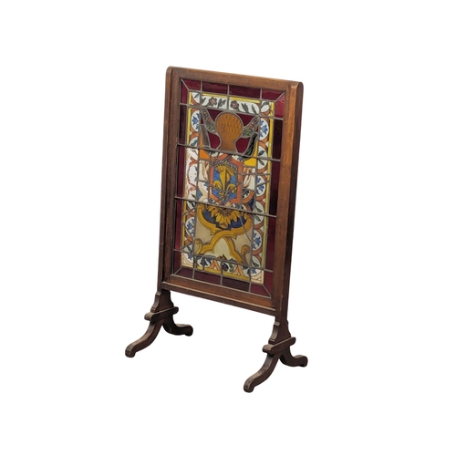 831 - An Edwardian mahogany stained glass fire screen. 53x102cm