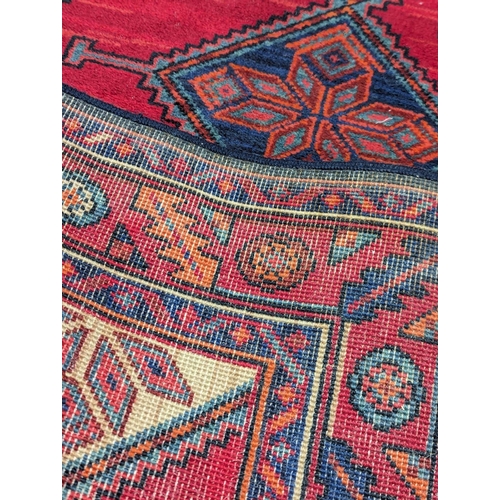 863 - A large 'Karijan' Middle Eastern hand knotted runner / rug. 259x99cm