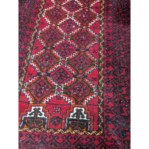 867 - A vintage Middle Eastern hand knotted runner / rug. 196x72cm