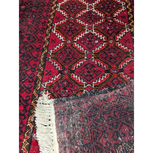 867 - A vintage Middle Eastern hand knotted runner / rug. 196x72cm