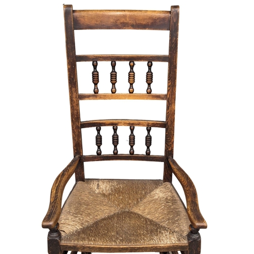 874 - A Mid 19th Century elm and beech rocking chair with rush seat.