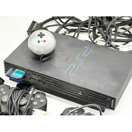 570 - A PS2 (PlayStation 2) console with 3 controllers.