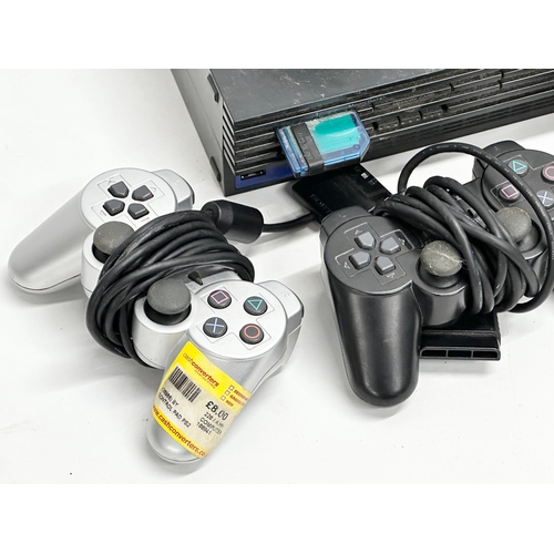 570 - A PS2 (PlayStation 2) console with 3 controllers.