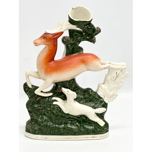 347 - A pair of 19th Century Victorian Staffordshire spill vases. Leaping deers and hounds. 21x29cm