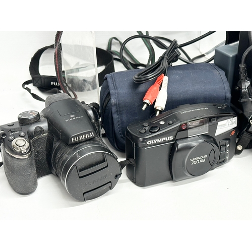 621 - A quantity of cameras. An Olympus Superzoom 700XB camera with case. A Fuji DL15 camera with case. A ... 