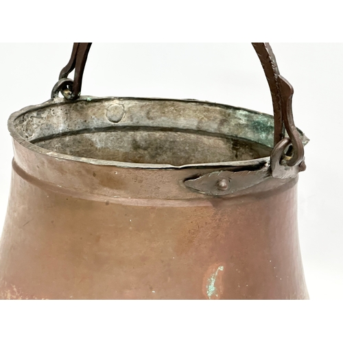 358A - A Late 19th Century copper pot with iron handle. 37x24cm