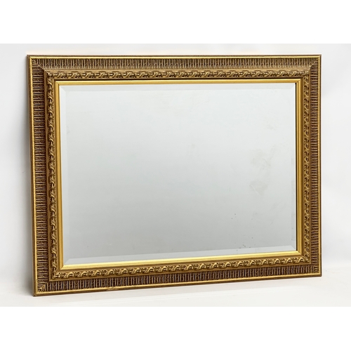 360B - A large Victorian style gilt framed bevelled mirror. 87x67cm