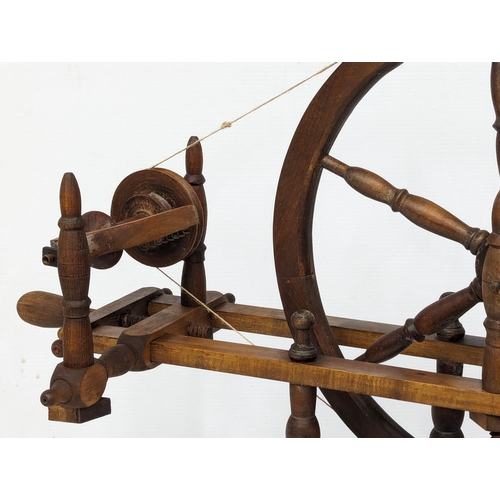 691 - An Early 20th Century spinning wheel. 76x78cm