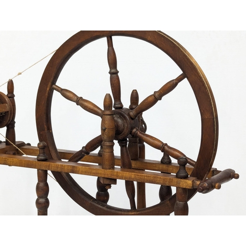 691 - An Early 20th Century spinning wheel. 76x78cm