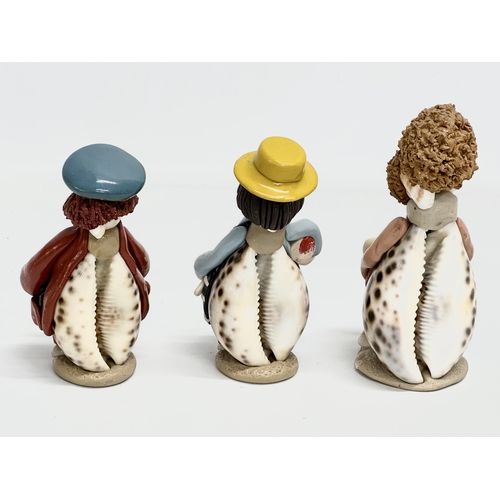 681 - A collection of cowrie seashell and clay figures. 16cm. 15cm