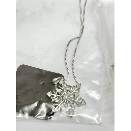 539I - A silver snowflake style necklace, with silver earrings and silver chain.