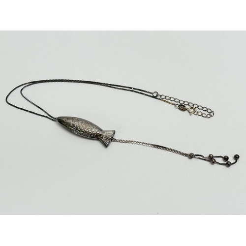 539Q - A silver necklace. Fish pendant measures 3.5cm