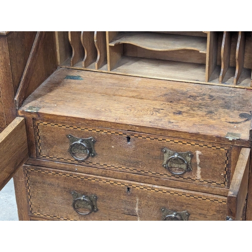 928 - An Early 20th Century Arts & Crafts inlaid oak writing bureau. Circa 1900. 100x43x111cm